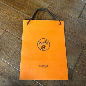 Authentic Hermes paper shopping bag in iconic orange color.